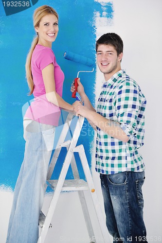 Image of happy couple paint wall at new home