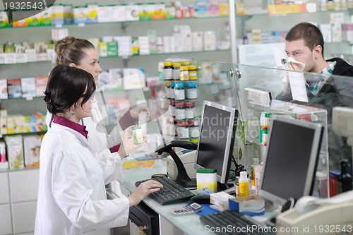 Image of pharmacist suggesting medical drug to buyer in pharmacy drugstor