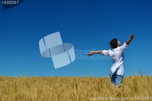 Image of young woman in wheat field at summer