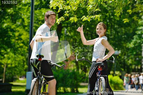 Image of Happy couple riding bicycle outdoors