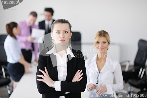 Image of business woman standing with her staff in background
