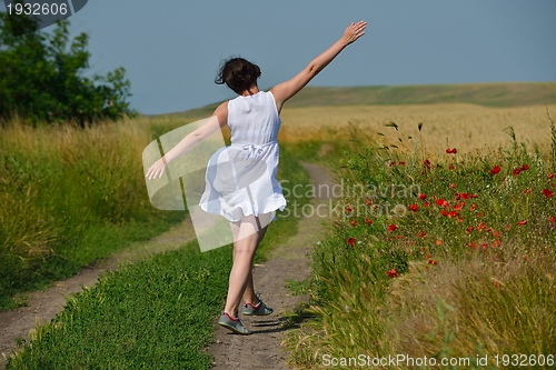 Image of young woman in wheat field at summer