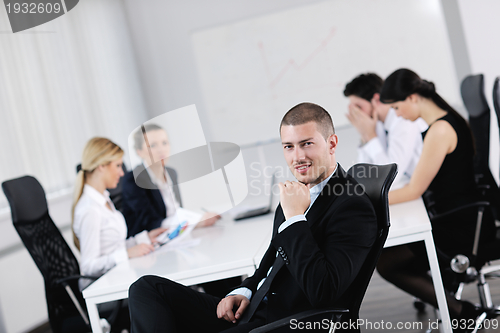 Image of handsome young business man with colleagues in background