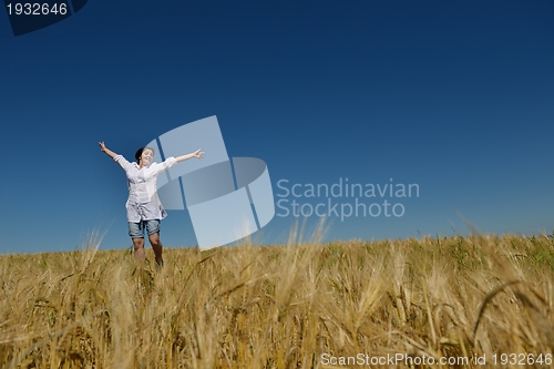 Image of young woman in wheat field at summer