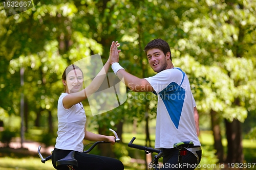 Image of Happy couple ridine bicycle outdoors