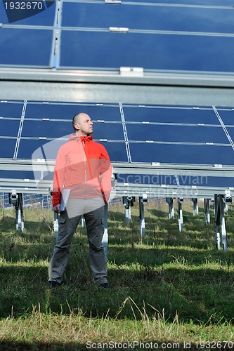 Image of engineer using laptop at solar panels plant field