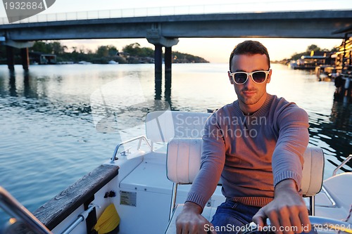 Image of portrait of happy young man on boat