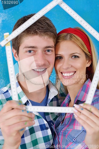 Image of happy couple paint wall at new home