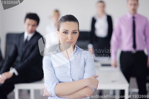 Image of business woman standing with her staff in background