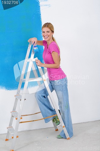 Image of happy couple paint wall at new home