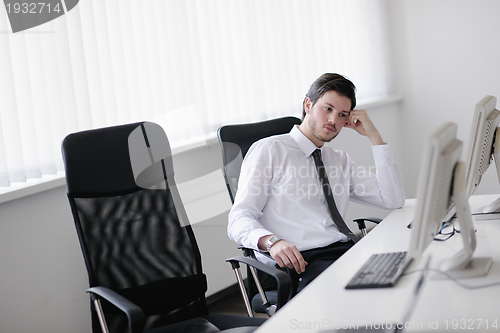 Image of tired and depresed young business man at office