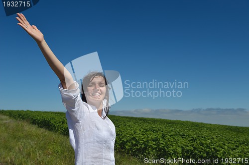 Image of Young happy woman in green field