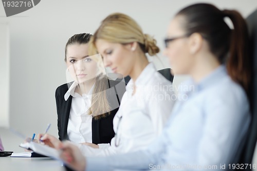 Image of business woman standing with her staff in background
