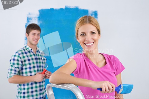 Image of happy couple paint wall at new home