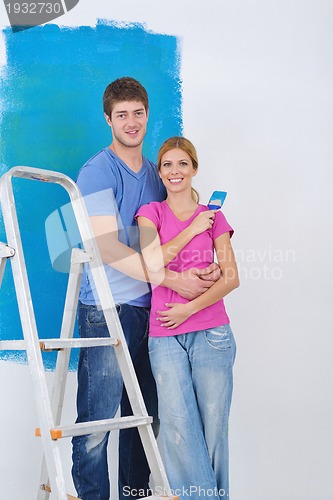 Image of happy couple paint wall at new home