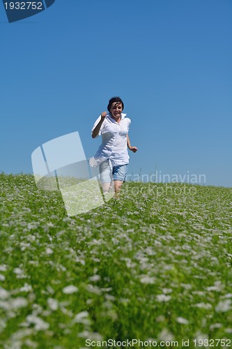 Image of Young happy woman in green field
