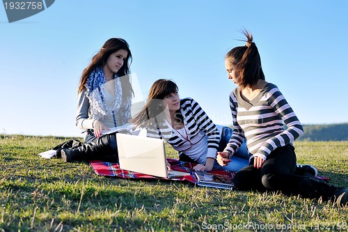 Image of group of teens working on laptop outdoor