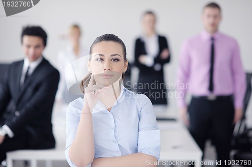 Image of business woman standing with her staff in background