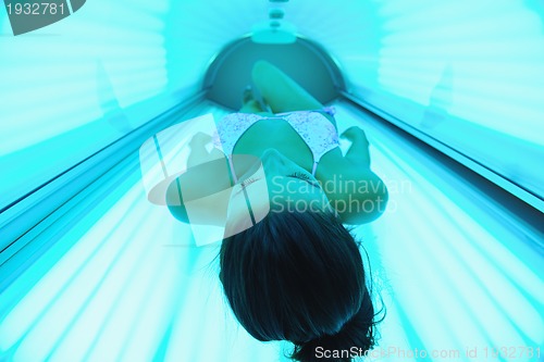 Image of Beautiful young woman tanning in solarium