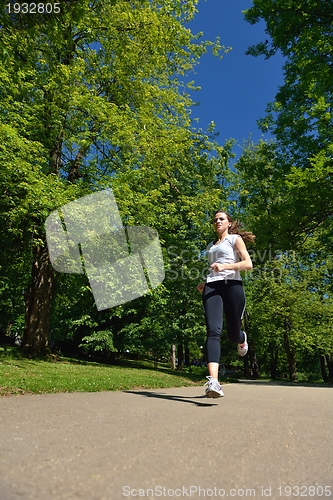 Image of Young beautiful  woman jogging at morning in park