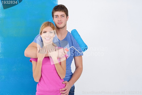 Image of happy couple paint wall at new home