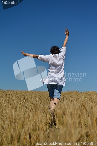 Image of young woman in wheat field at summer