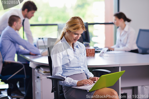 Image of business woman with her staff in background at office