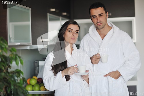 Image of Young love couple taking fresh morning cup of coffee