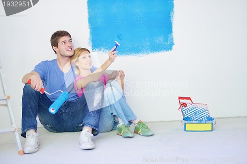 Image of happy young cople relaxing after painting in new home