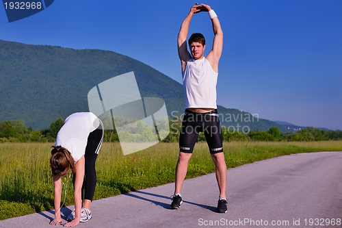 Image of Couple doing stretching exercise  after jogging