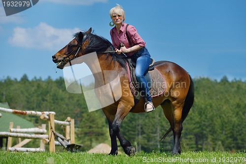 Image of happy woman  on  horse