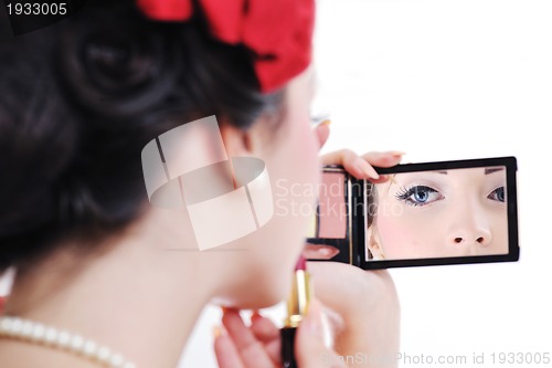 Image of beautiful young woman applying makeup