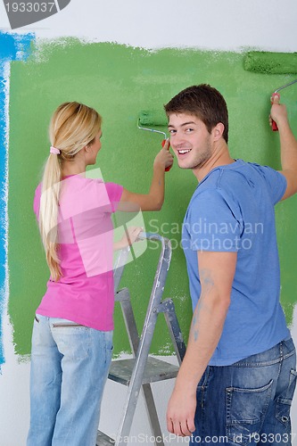 Image of happy couple paint wall at new home