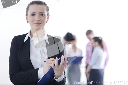 Image of business woman standing with her staff in background