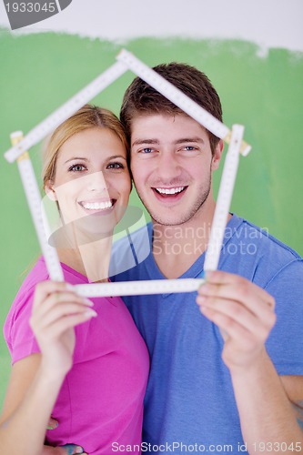 Image of happy couple paint wall at new home