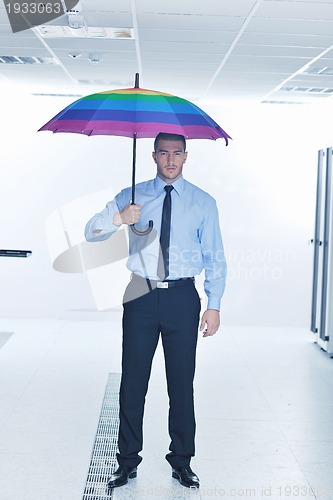 Image of businessman hold umbrella in server room