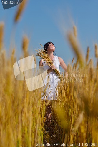 Image of young woman in wheat field at summer