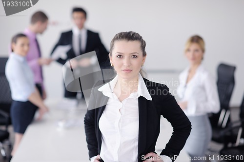 Image of business woman standing with her staff in background