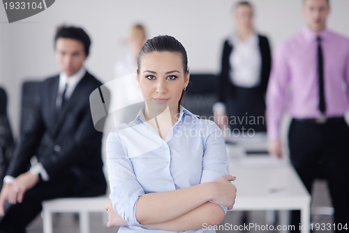 Image of business woman standing with her staff in background