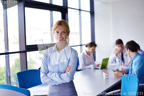 Image of business woman with her staff in background at office