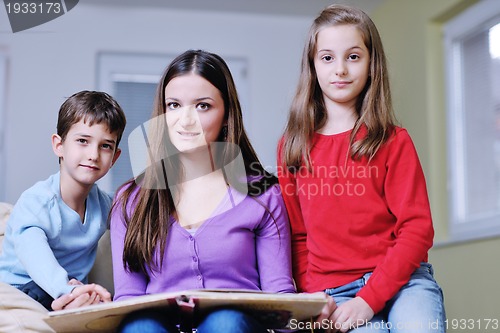 Image of young mom play with their kids at home and reading book