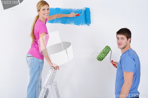 Image of happy couple paint wall at new home