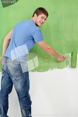 Image of handsome young man paint white wall in color