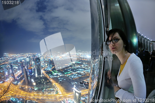 Image of beautiful woman portrait with big city at night in background