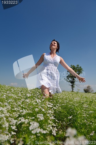 Image of Young happy woman in green field