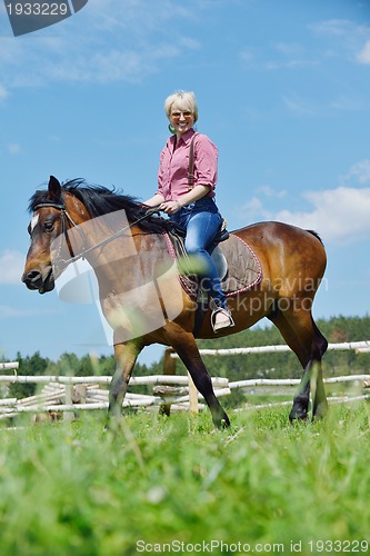 Image of happy woman  on  horse