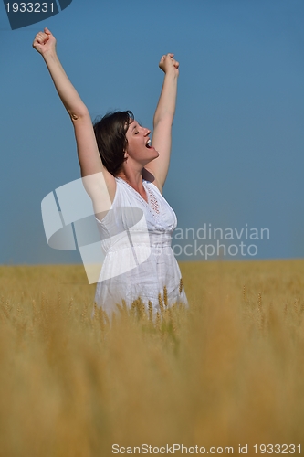 Image of young woman in wheat field at summer