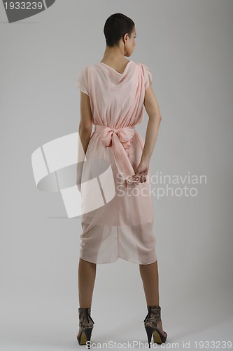 Image of elegant woman in fashionable dress posing in the studio