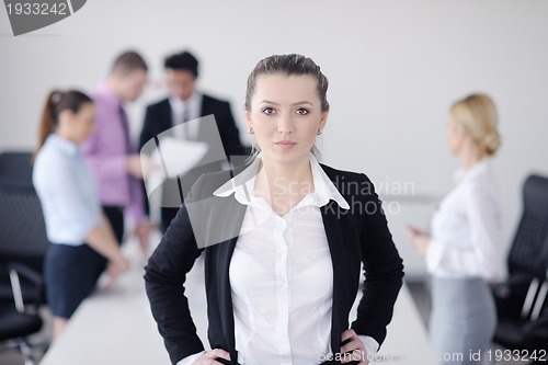 Image of business woman standing with her staff in background