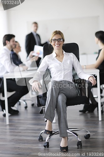 Image of business woman with her staff in background